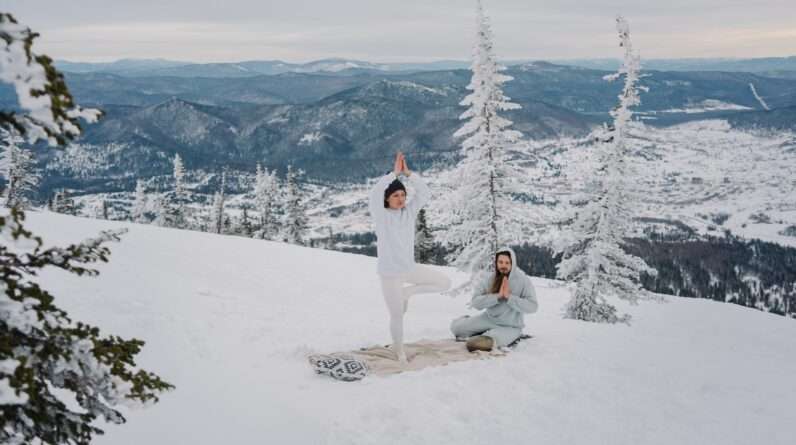 A Couple Meditating Together on a Snow Covered Ground
