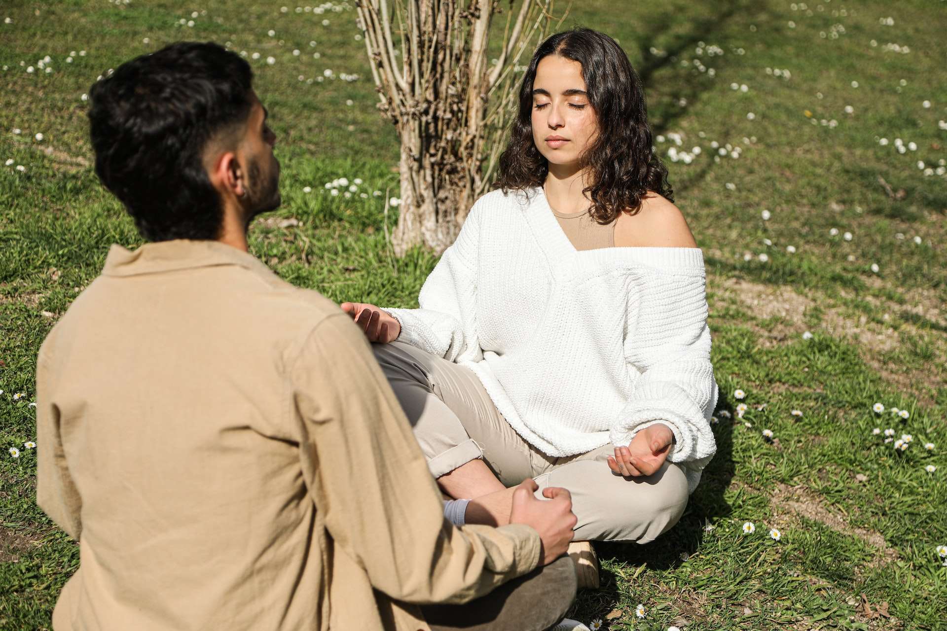 A Couple Meditating while Sitting on a Grassy Ground 