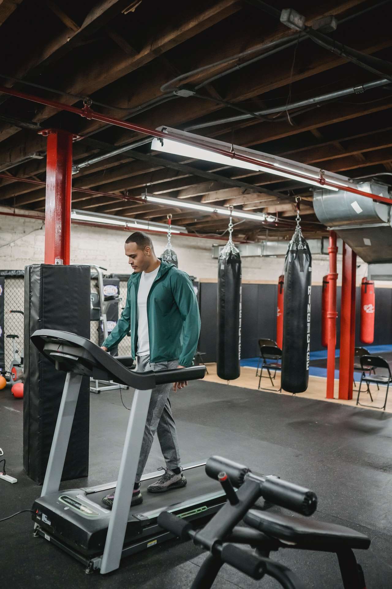 Athletic man preparing treadmill in gym 