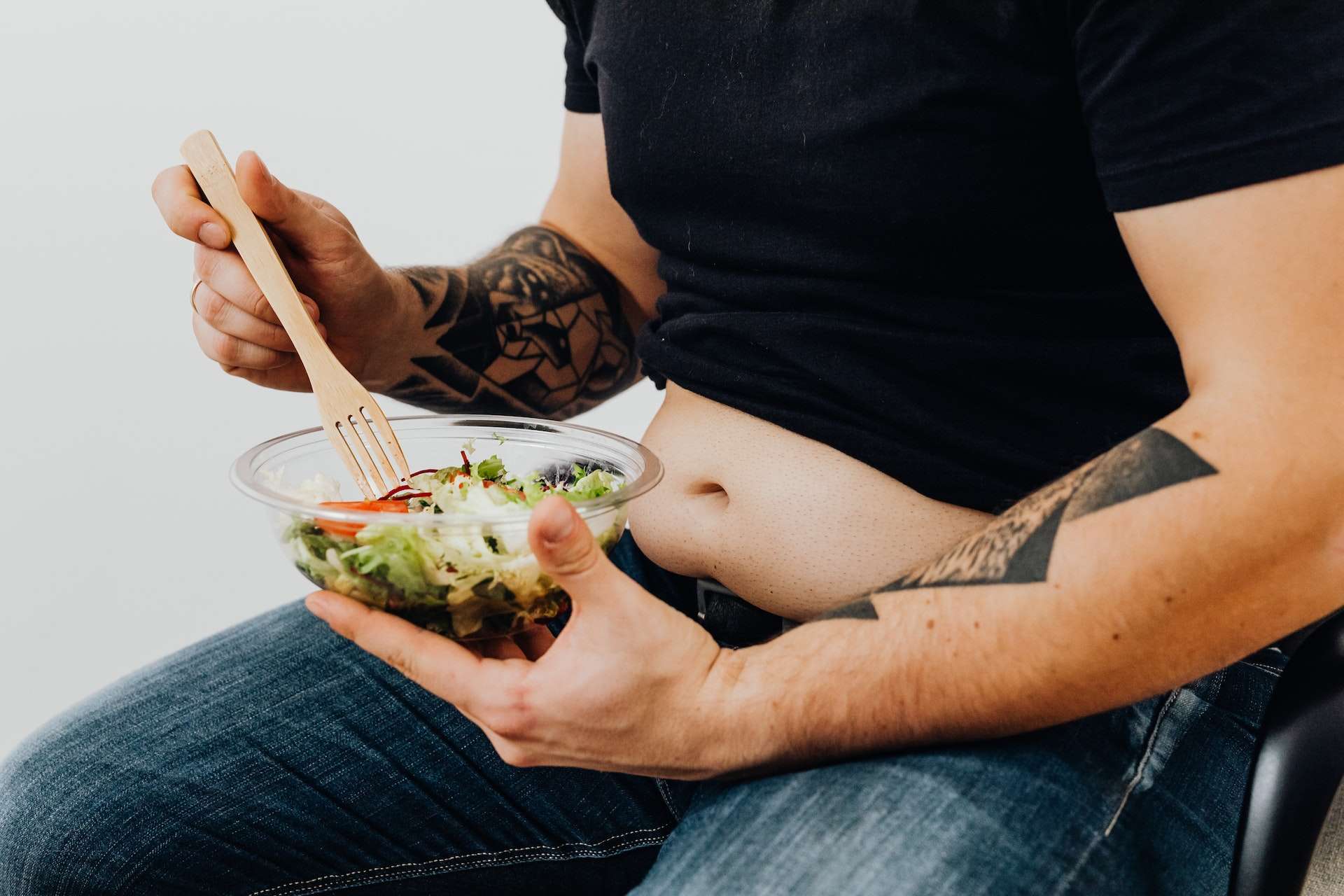 Close-Up Shot of a Tattooed Man Holding a Fresh Vegetable Salad