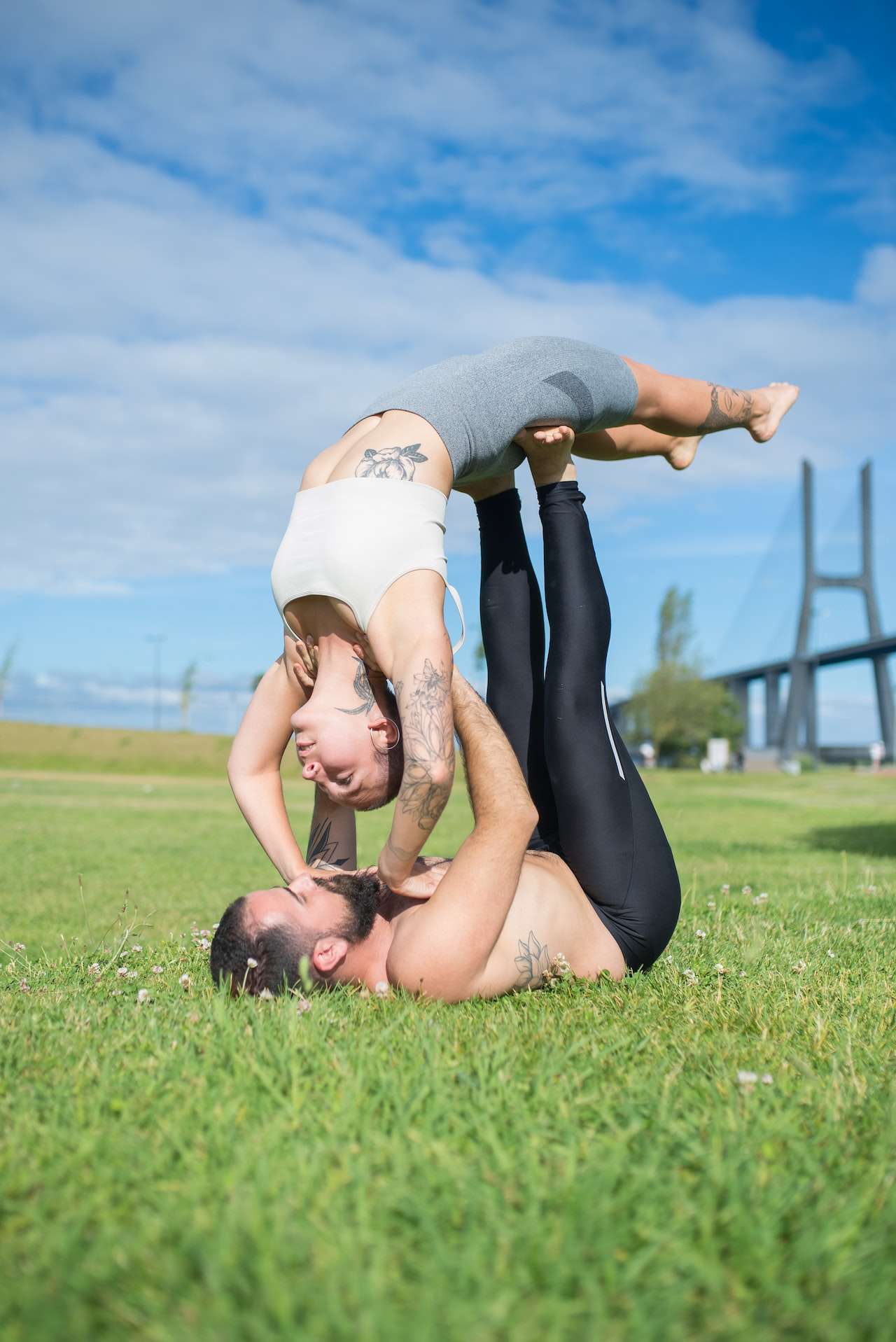 Couple Doing Yoga Poses on the Green Field 