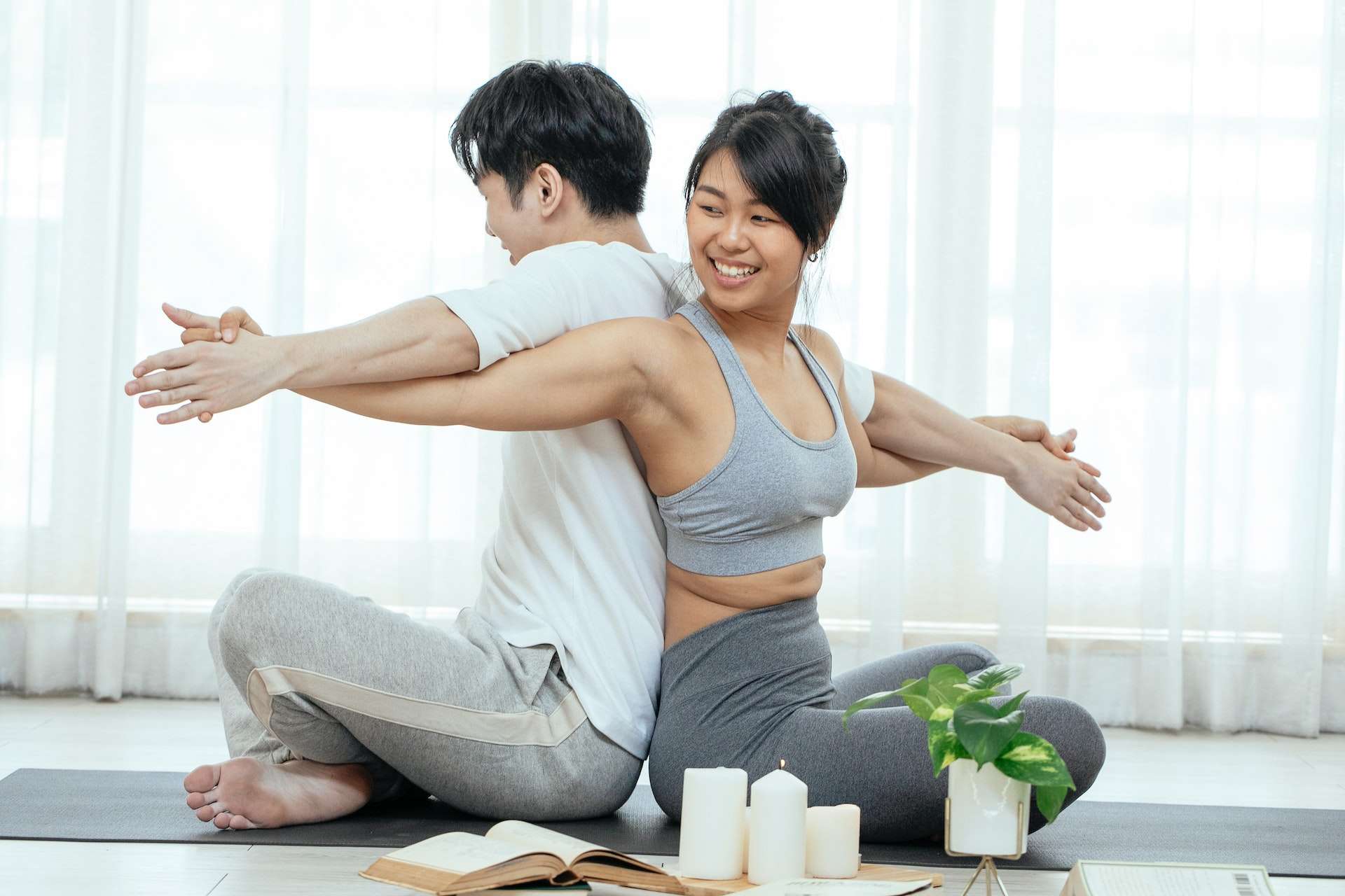 Happy man and woman doing partner eagle yoga pose