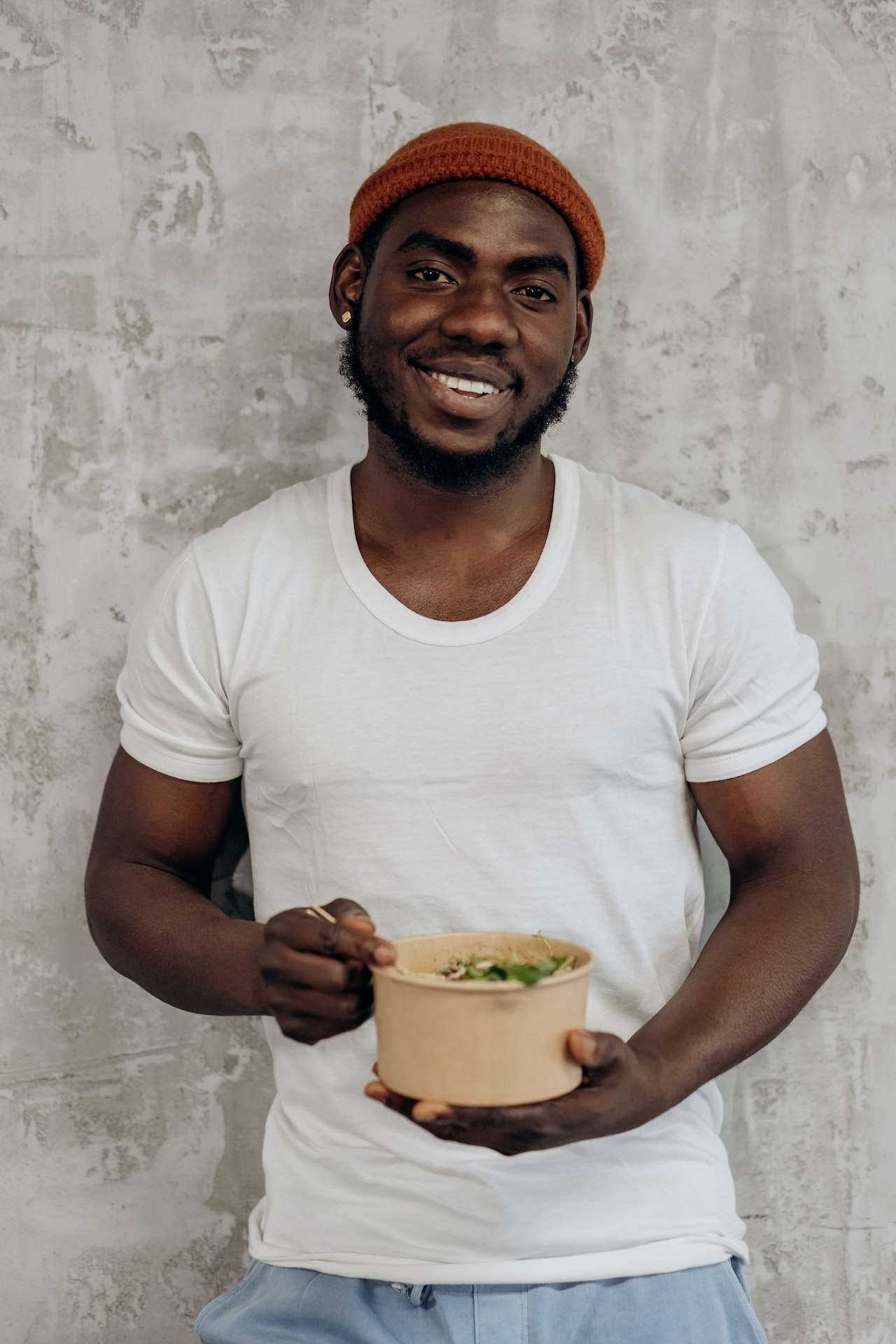 Man in White Crew Neck T-shirt Holding A Bowl of plant based salad