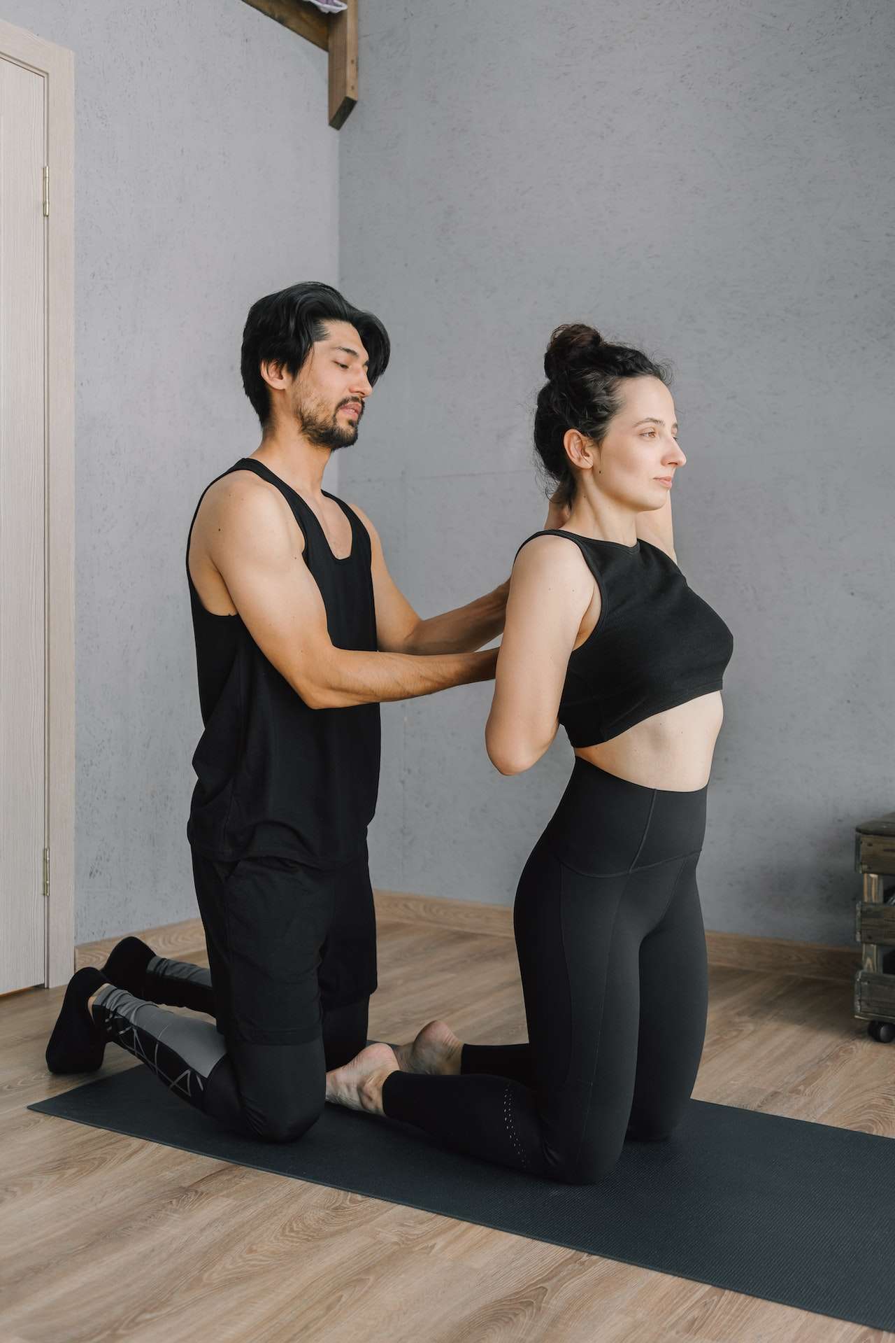 Photo of Man Assisting a Woman Stretching her Arms 