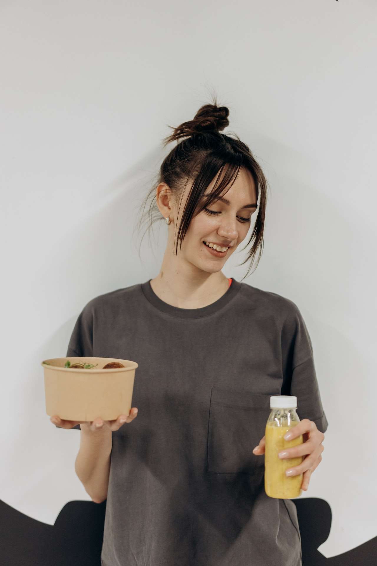 Woman Holding a bowl of salad and smoothie