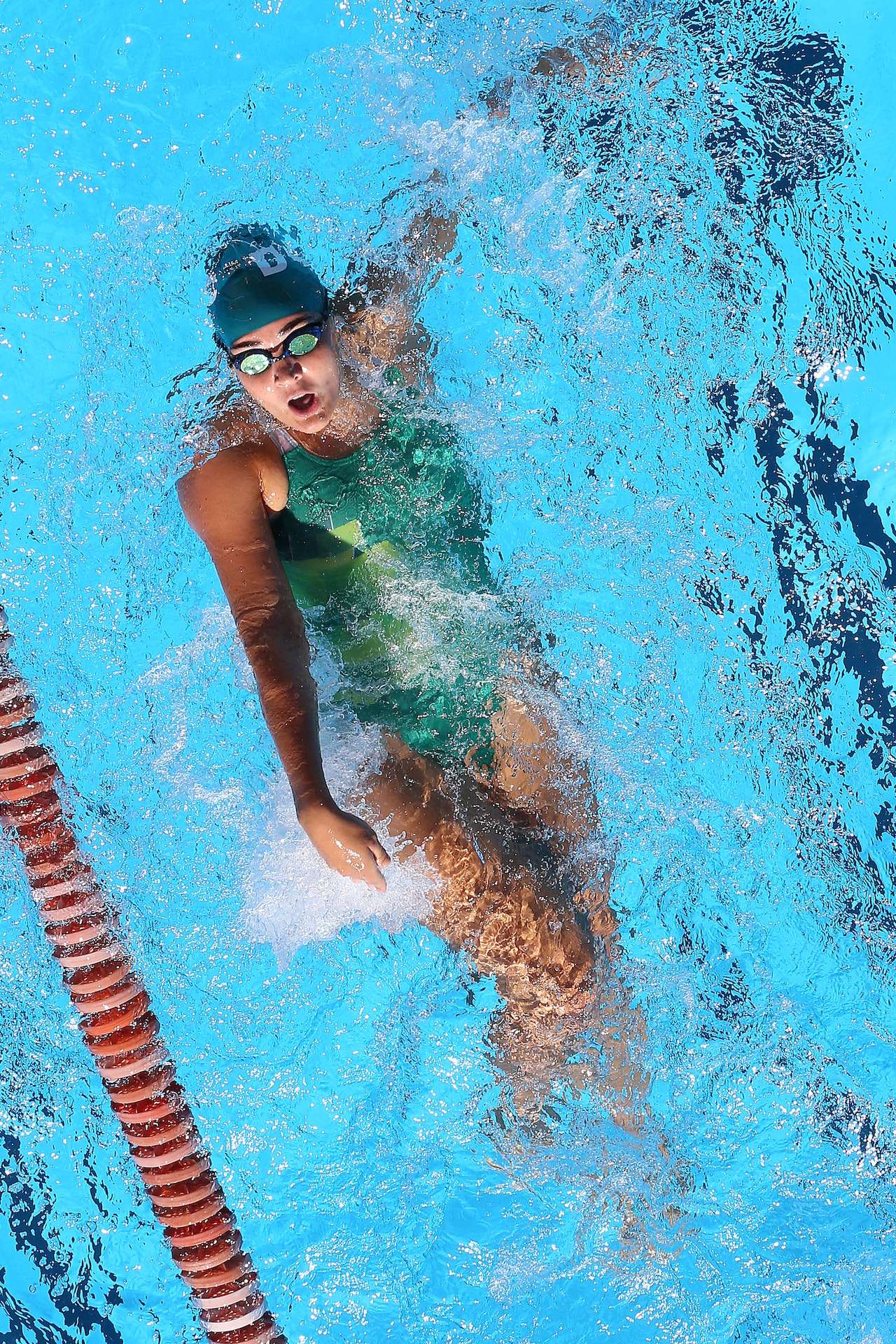 Woman In Green Swimsuit doing backstroke