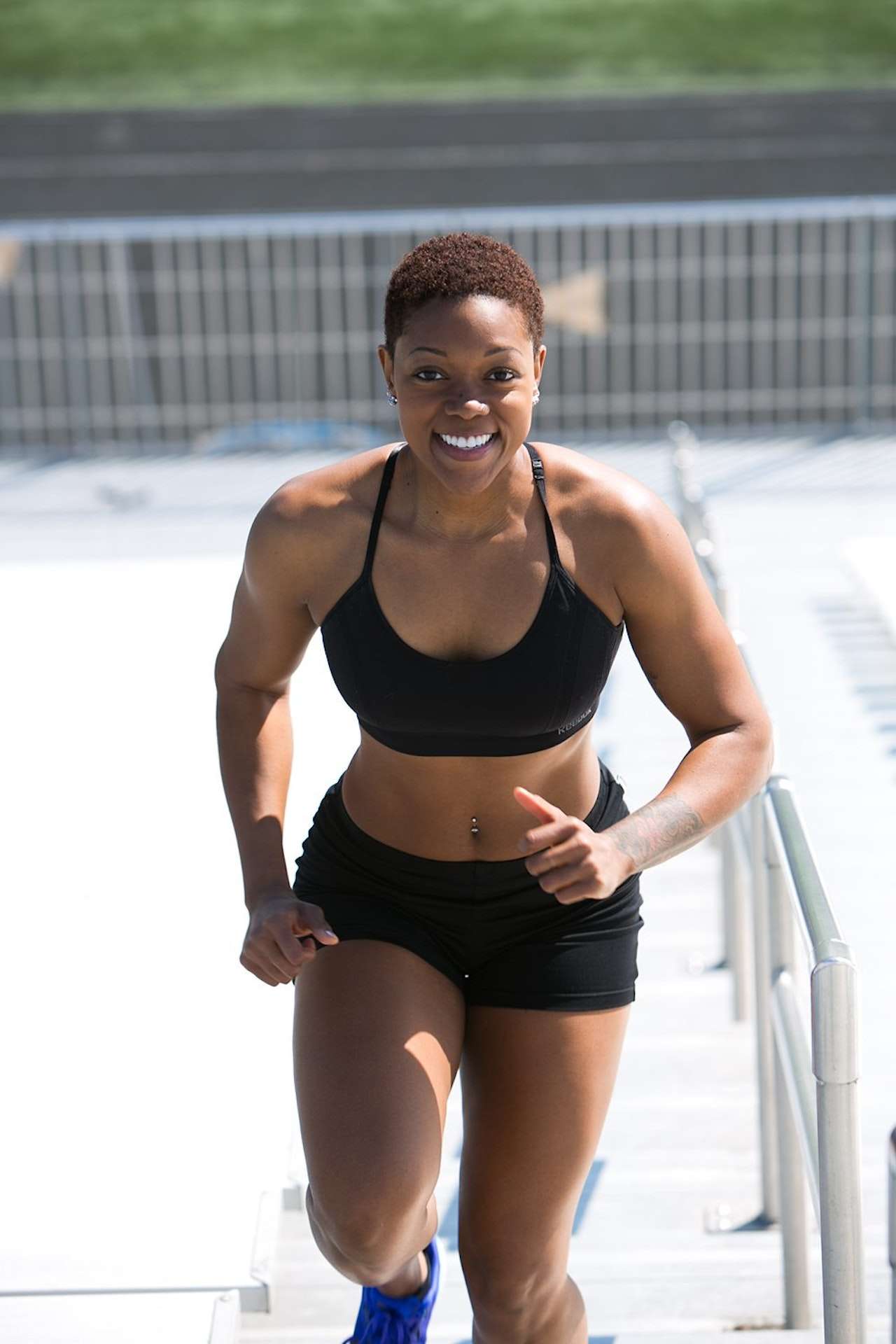 Woman Wearing Black Sports Bra and Jogger Shorts Smiling 