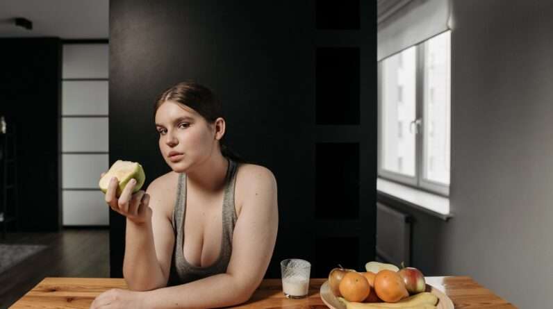 Woman in Gray Tank Top Holding an Apple