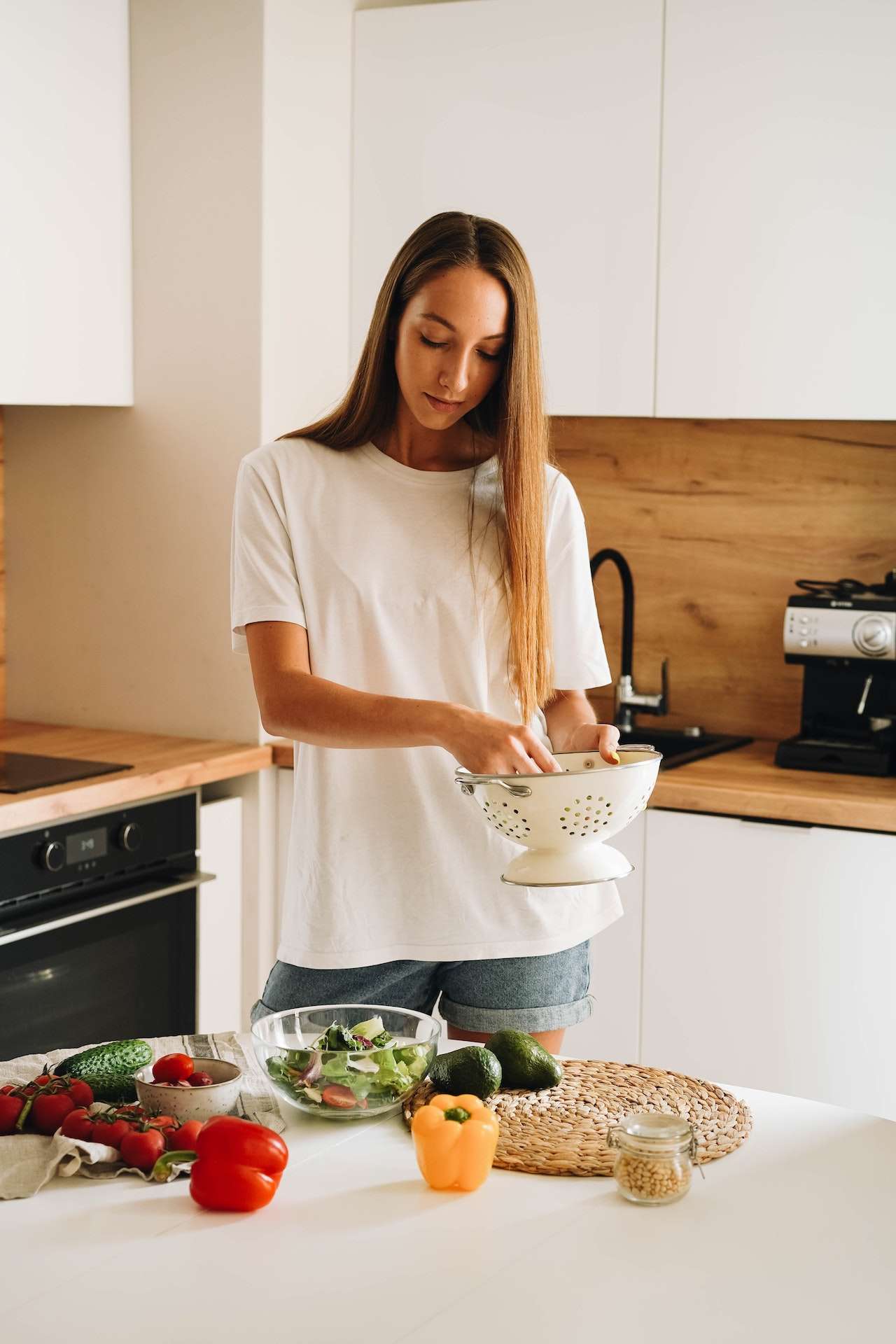 Woman in White T-shirt Holding White Metal Colander for her healthy salad
