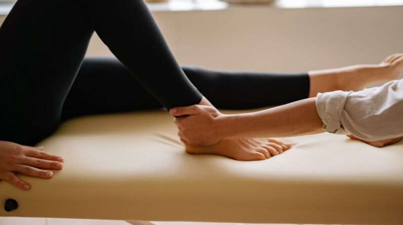 A Massage Therapist Holding Patient's Foot