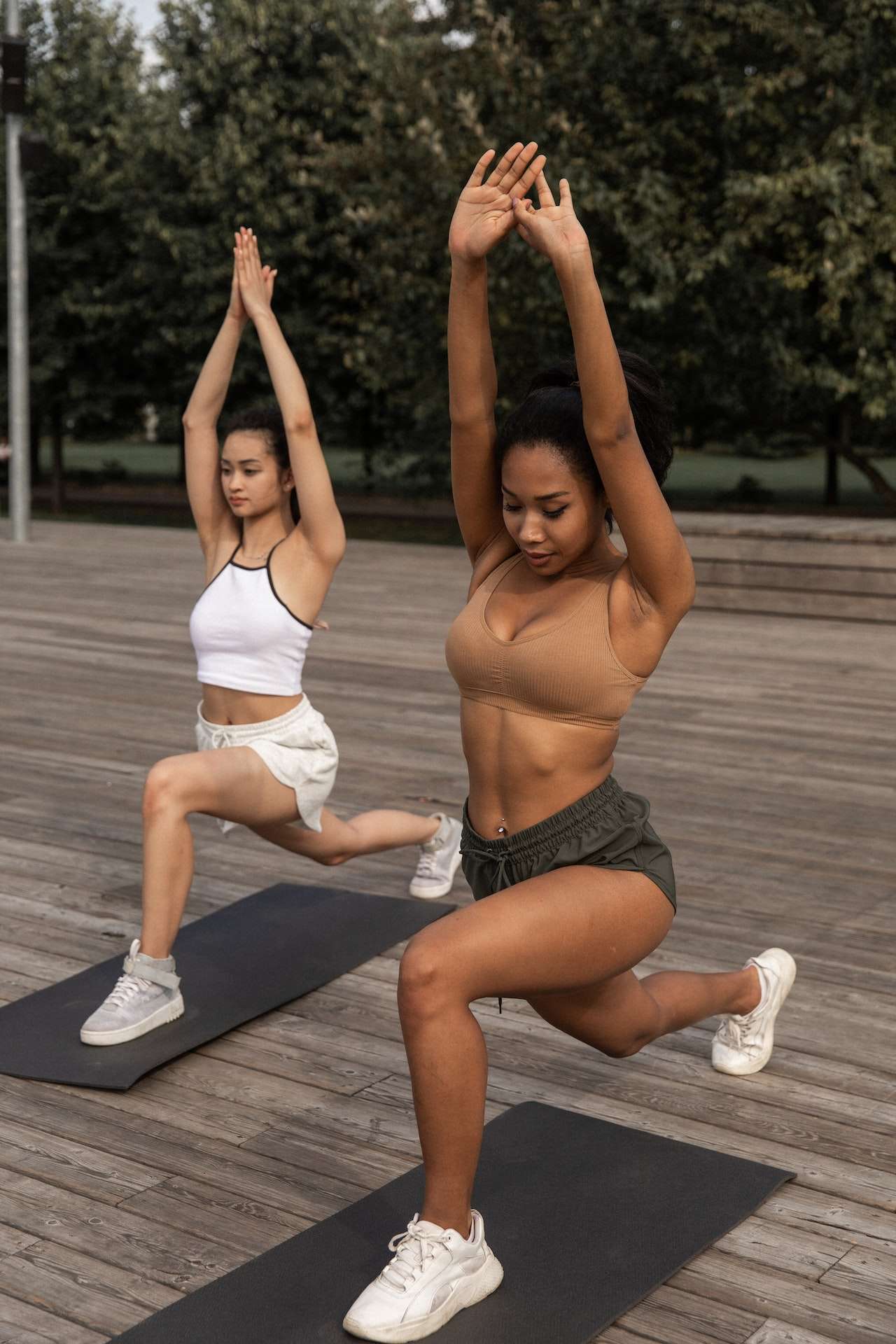 Diverse women doing Crescent Lunge pose together

