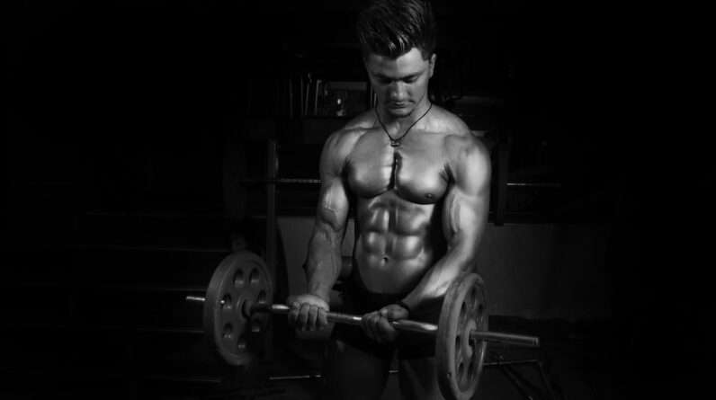 Grayscale Photography of Man Carrying Barbell