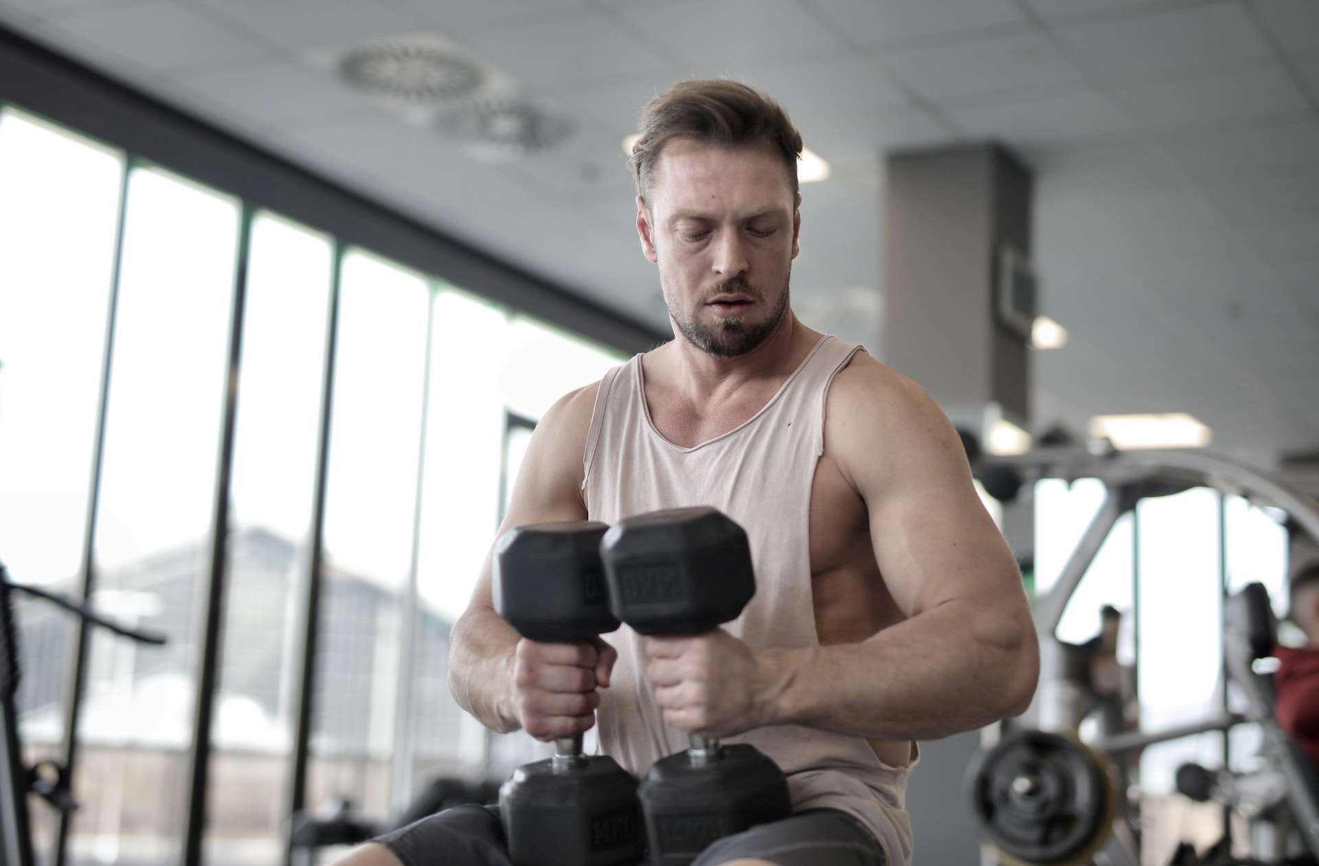 Man In Tank Top Holding Dumbbells