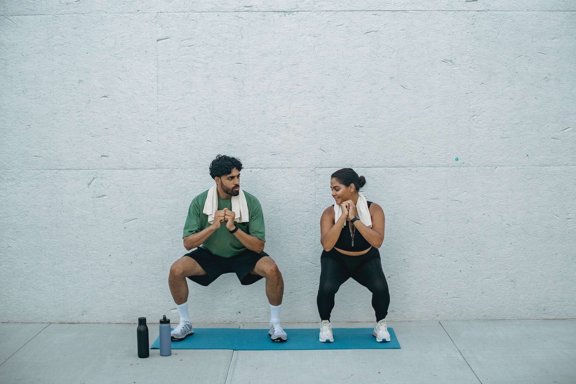 Man and Woman Doing Squats during a Workout
