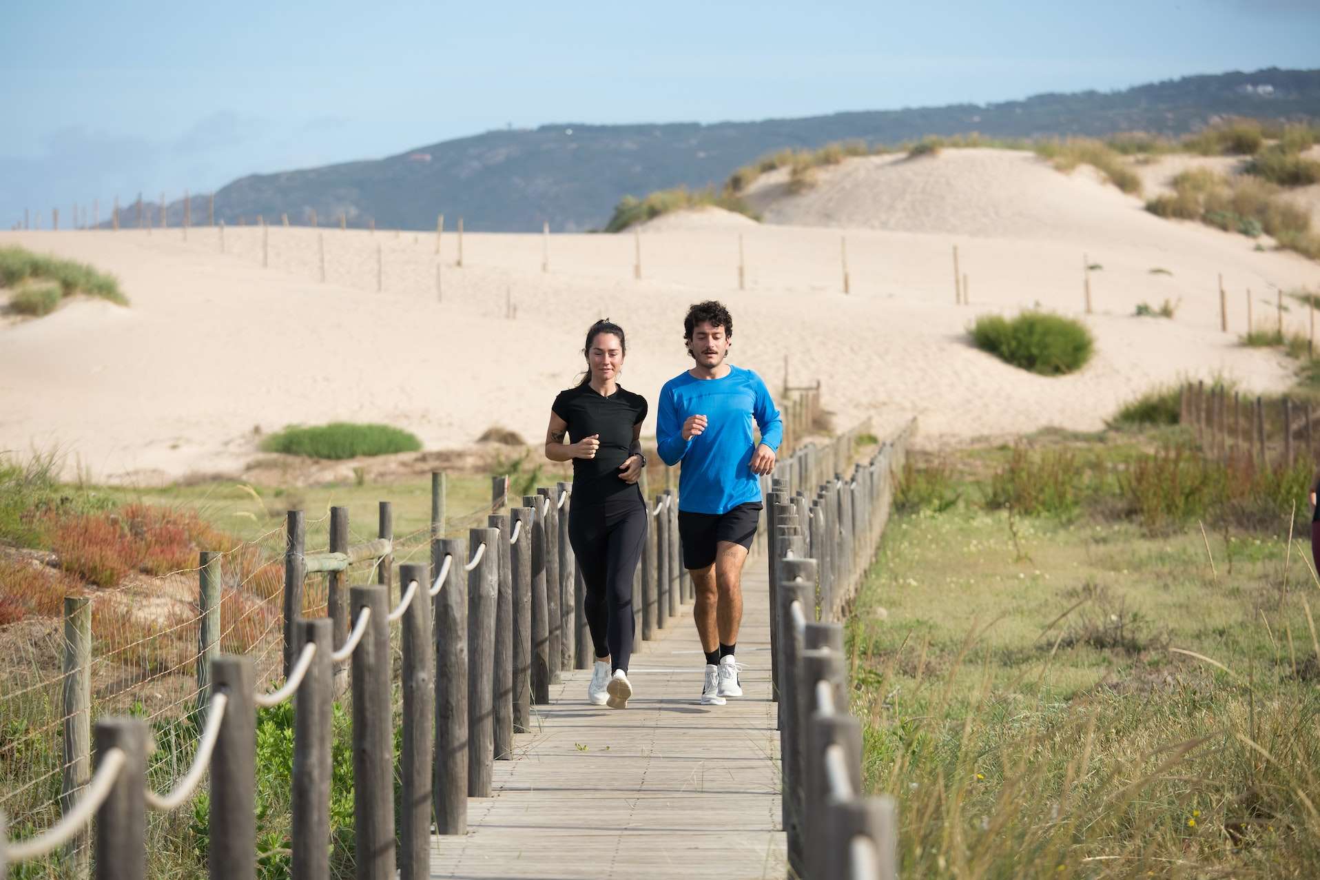Man and Woman Jogging on a Boardwalk
