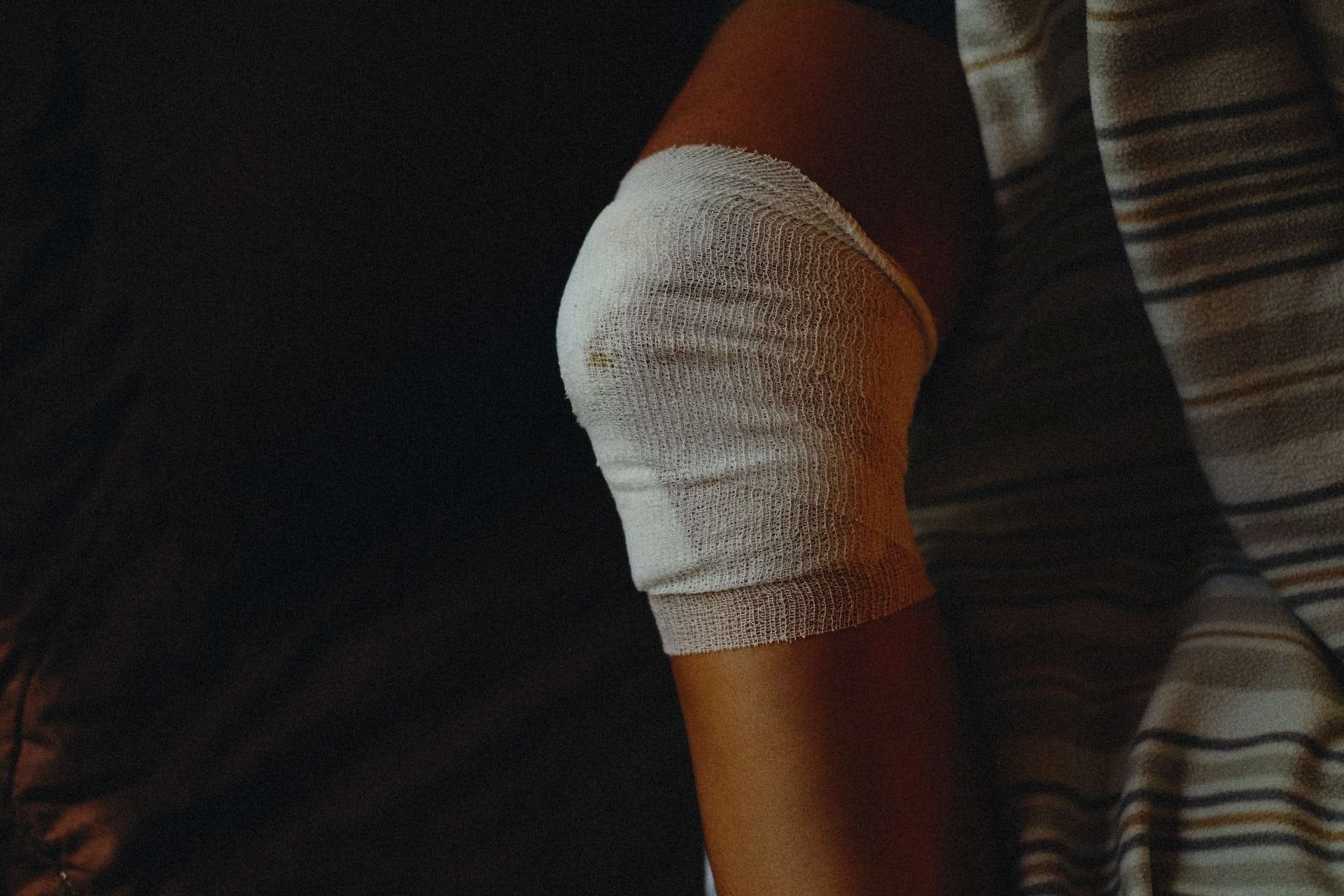 Person with Medical Gauze Bandage on Injured Knee
